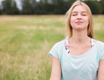 Young woman with eyes closed experiencing harmony with nature