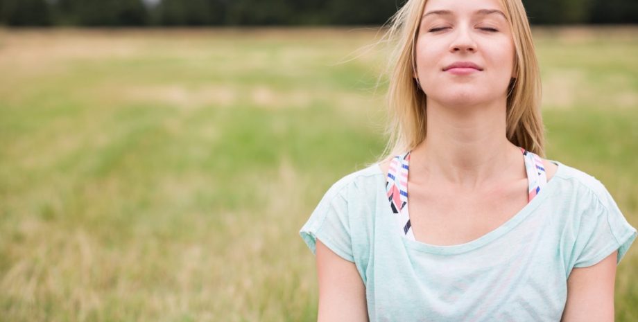 Young woman with eyes closed experiencing harmony with nature