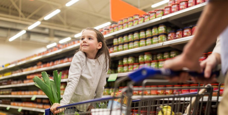 happy child and father with shopping cart buying food at grocery store