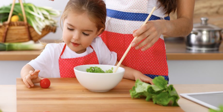 Mother and child daughter cooking tasty meal