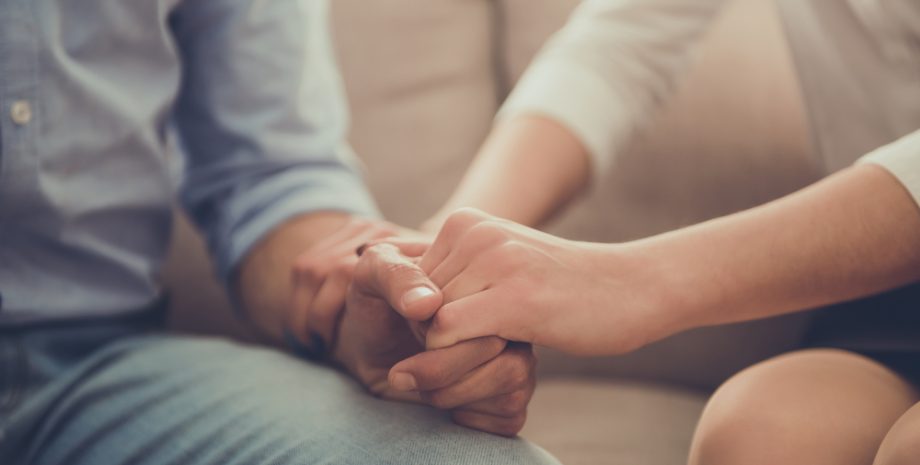 Female psychologist holder her client's hand