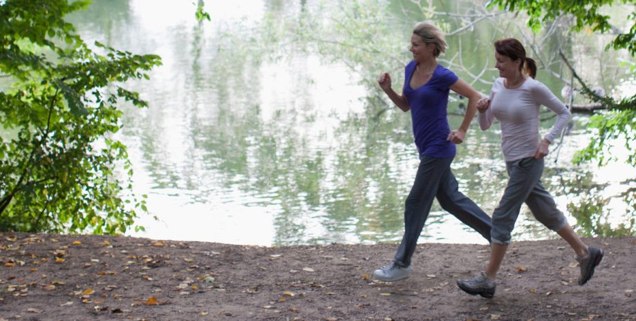 Women jogging together near lake
