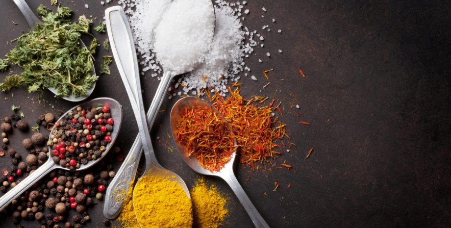 Various spices spoons on stone table.
