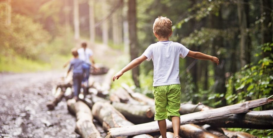 Children balancing on tree trunks