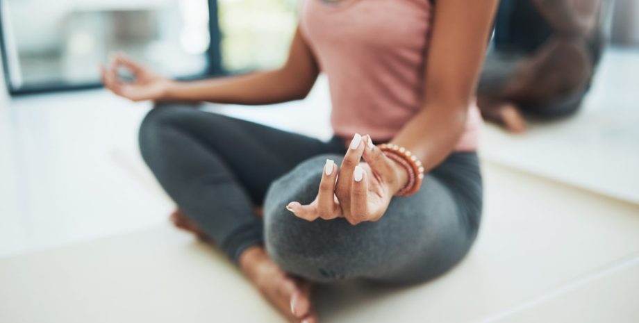 Woman doing a yoga pose on the floor inside of a studio