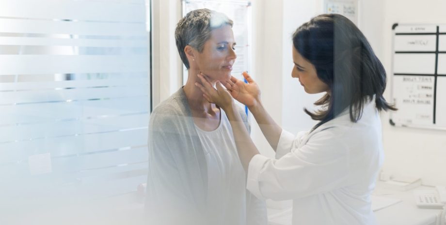 Doctor examining patient's thyroid glands.