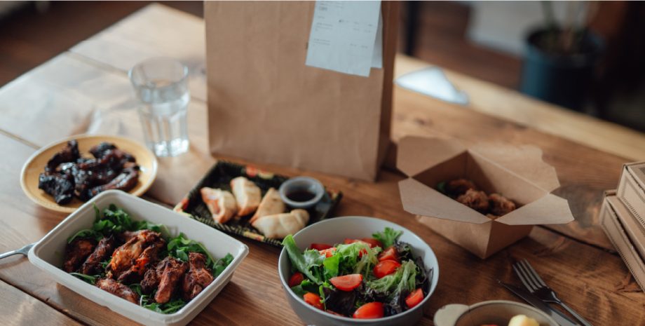 Takeout food ordered in front of a brown bag.