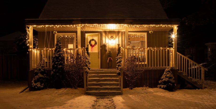 A house covered in snow and holiday decorations.