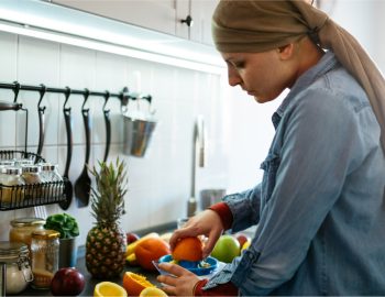 A woman preparing various fruits in her kitchen.