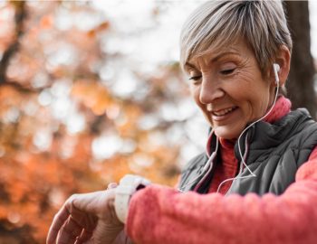 Elderly woman checking her watch to read her heart rate.