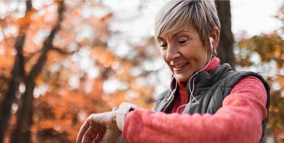 Elderly woman checking her watch to read her heart rate.