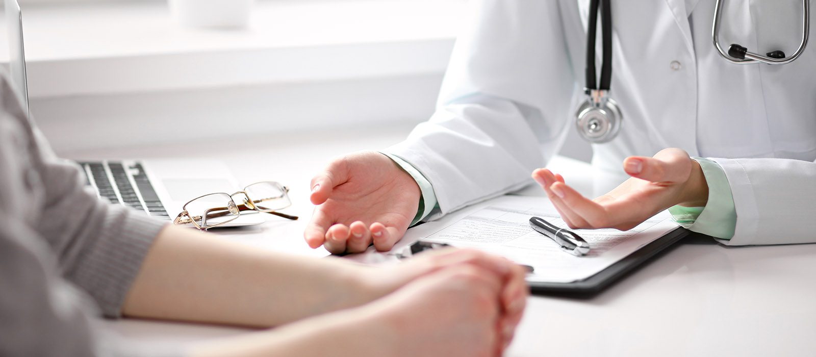 closeup of doctor's hands while to a female patient