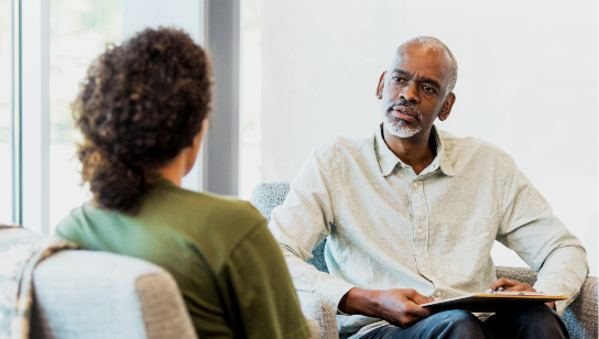 Mature male therapist counsels female patient
