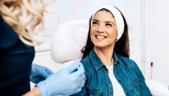 smiling young woman consults with a nurse about plastic surgery at Hancock Health