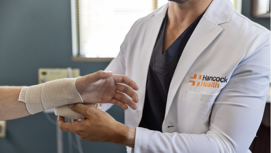 Hancock Health doctor wrapping the wrist of a patient