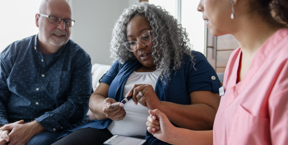 A nurse helping a couple read their diabetes test.