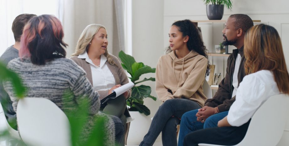 A group of adults sitting in a circle in some sort of discussion.