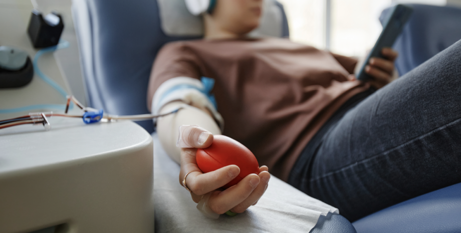 Close up if someone's hand clenching a pressure-balloon as they donate blood.